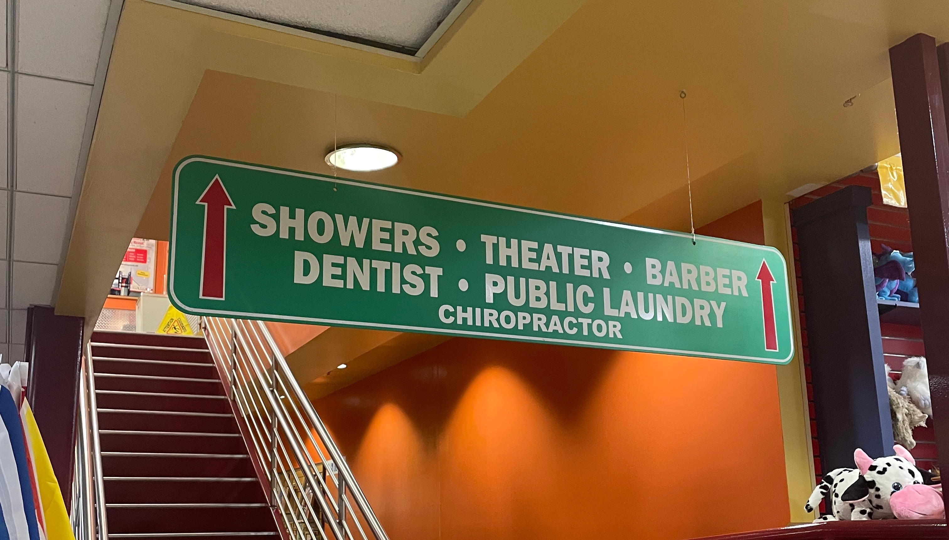 Image of a sign in the world's largest truck stop, indicating services upstairs